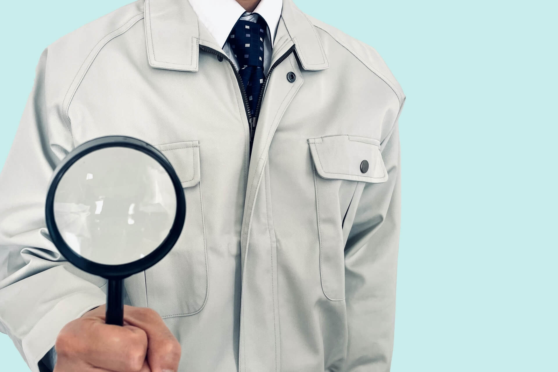 作業服の人が拡大鏡を持つ様子