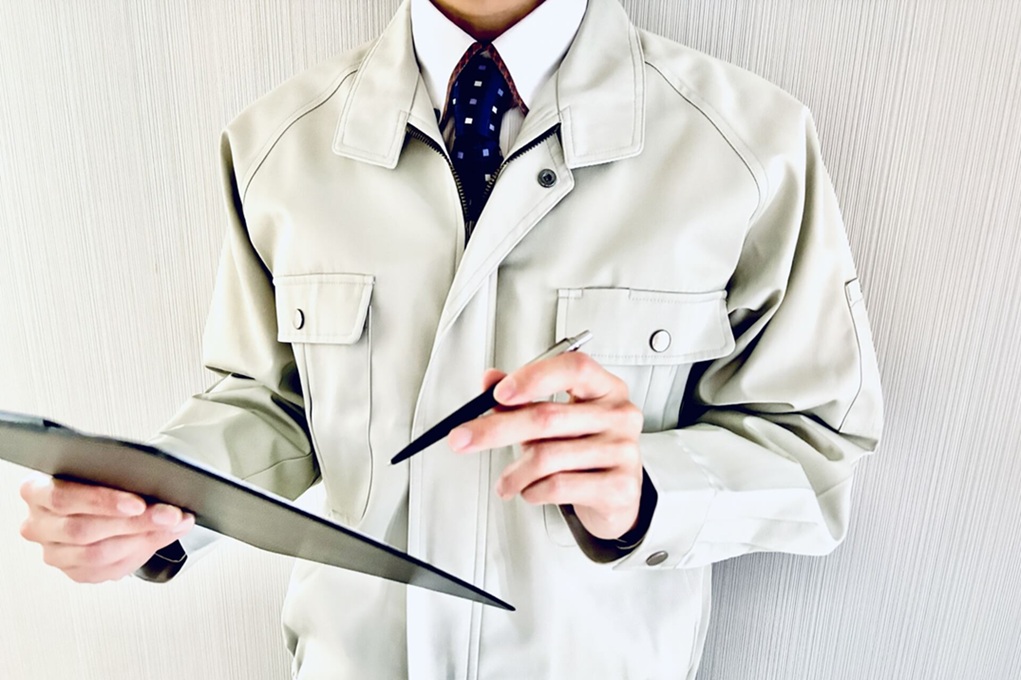 作業服を着た人がクリップボードを見る